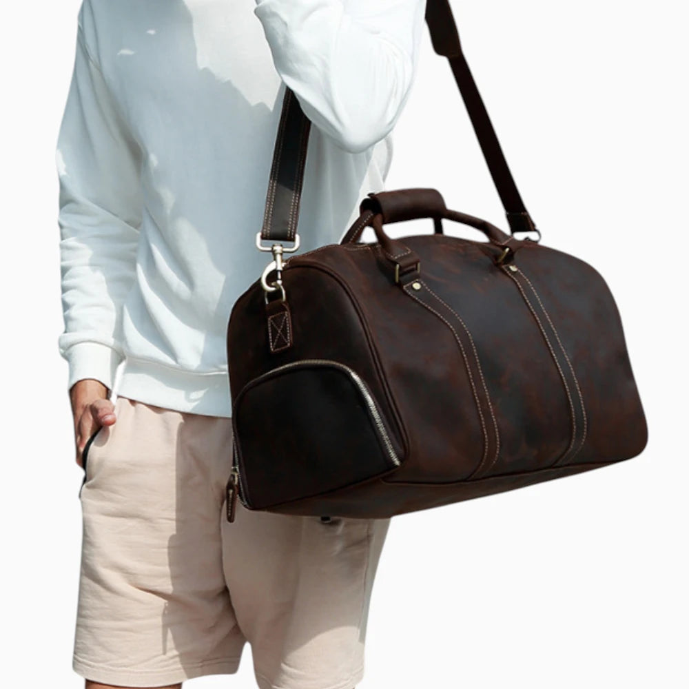 Sac de voyage en cuir pour homme, modèle Monaco, de couleur marron, avec poignées et bandoulière.