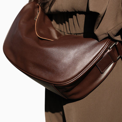 Sac banane en cuir marron pour femme modèle Pépite de la marque Élégance Cuir, porté sur l'épaule.