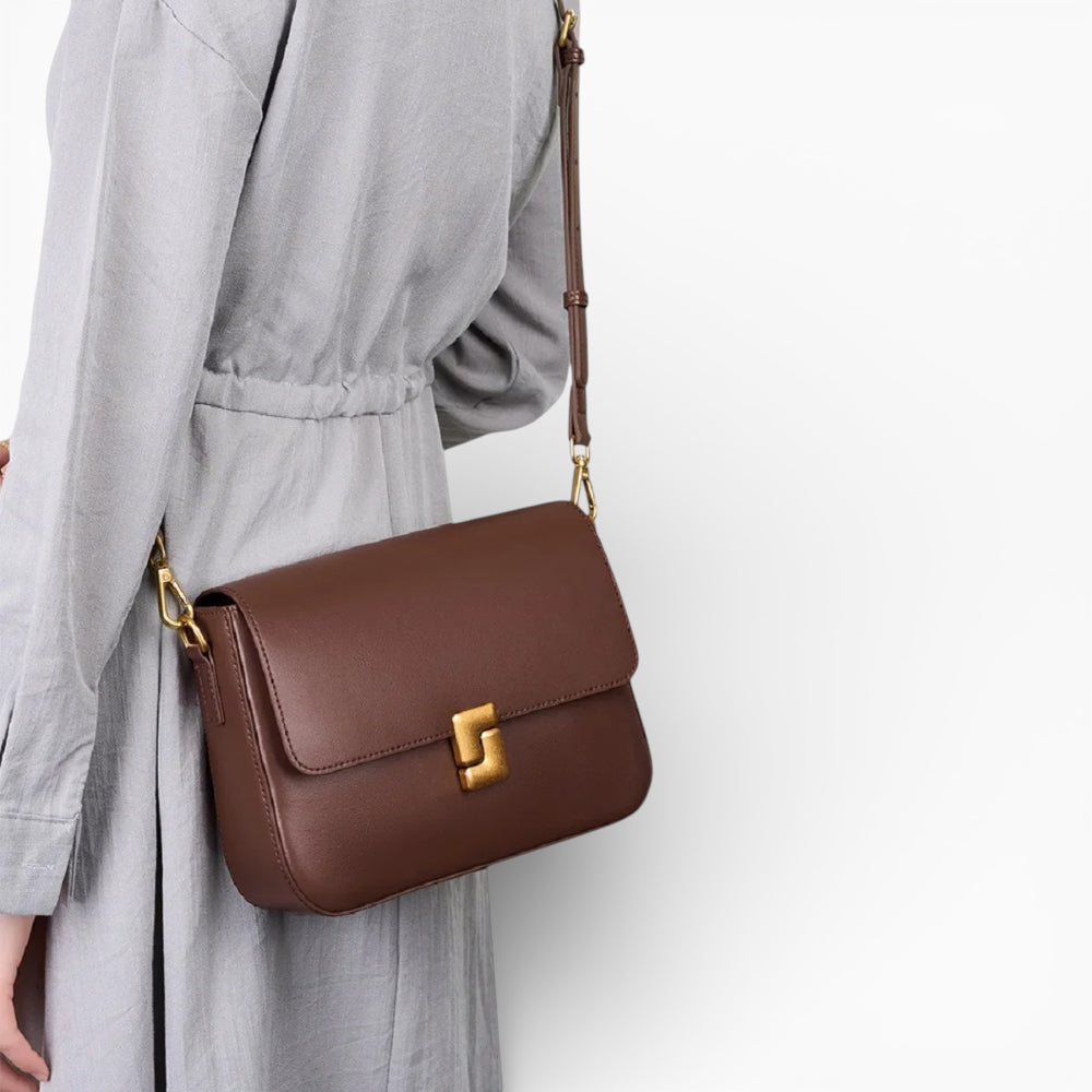 Sac bandoulière en cuir marron pour femme, modèle Céline avec rabat et fermoir métallique, porté sur l'épaule.