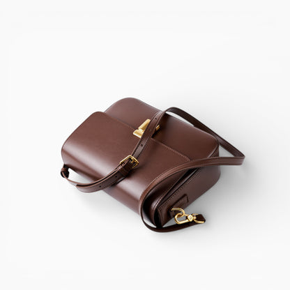 Sac bandoulière en cuir marron pour femme, modèle Celine avec rabat et fermoir métallique sur le côté.