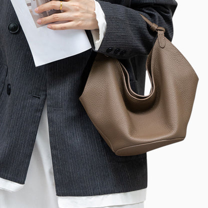 Sac hobo souple en cuir pour femme modèle Amaya, porté au bras par un mannequin, couleur marron.