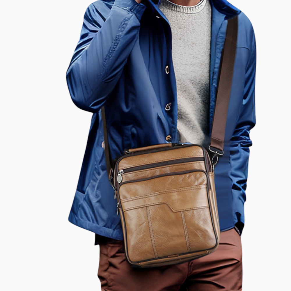 Sacoche bandoulière en cuir marron pour homme, format vertical avec poche zippée, modèle Alliance sur mannequin.